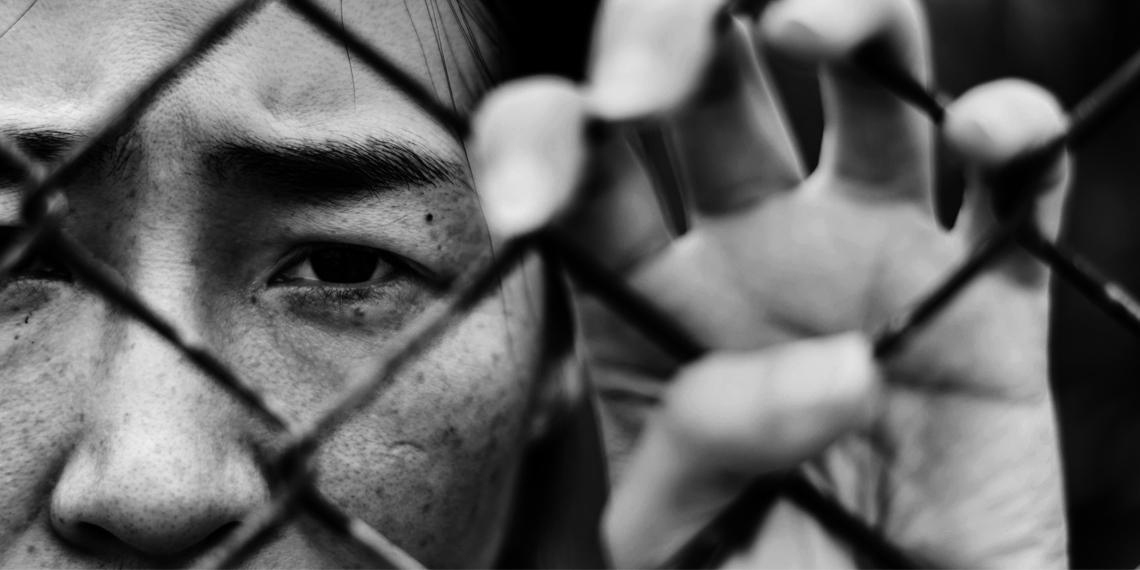 a child behind a chain link fence