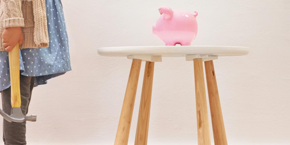 a girl with a hammer waiting to smash a piggy bank