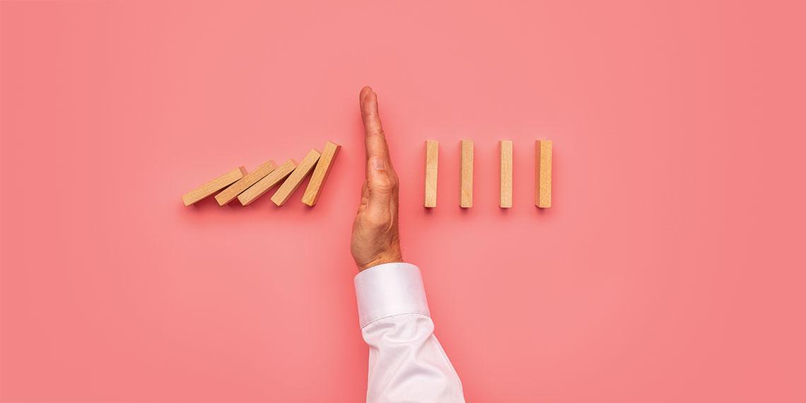 Hand blocking dominoes from continuing to fall