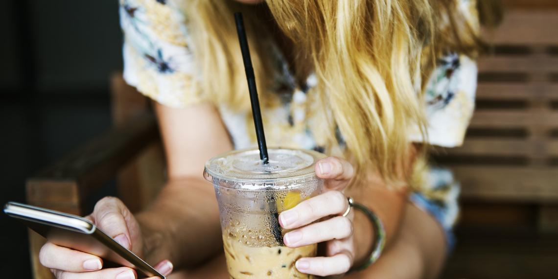 Cup of drink in hands of woman