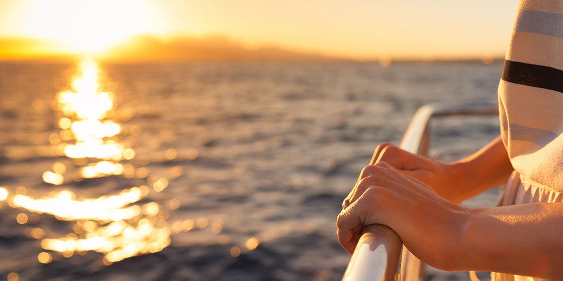Woman looking out over sunlit still water