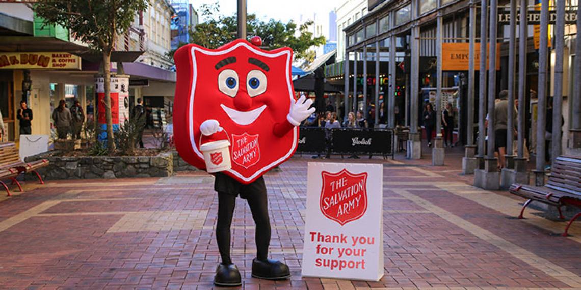 Red shield mascot with collecting bucket