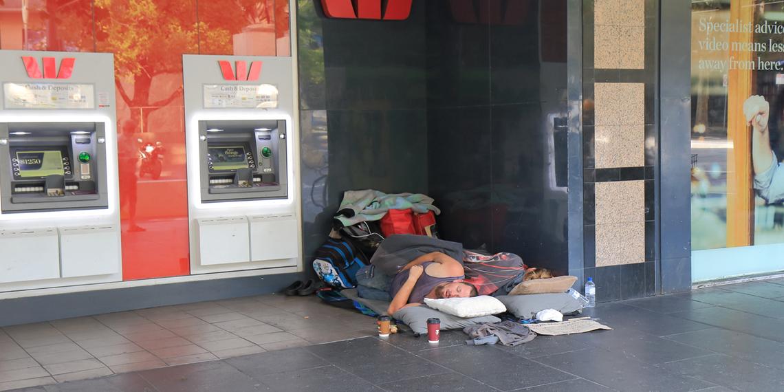 a homeless couple sleeping in front of a Westpac bank branch