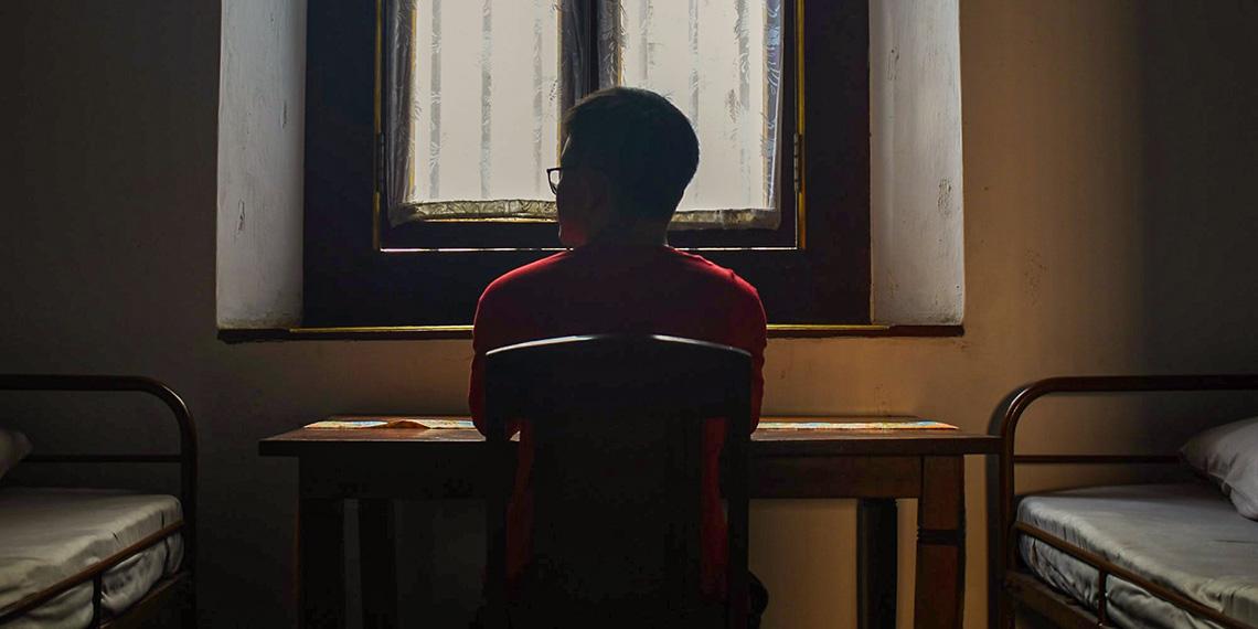 Person by window in sparse room
