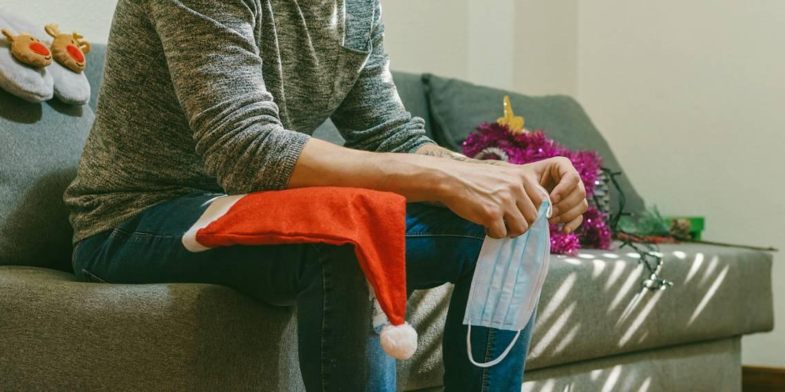 Man sitting with santa hat and covid mask
