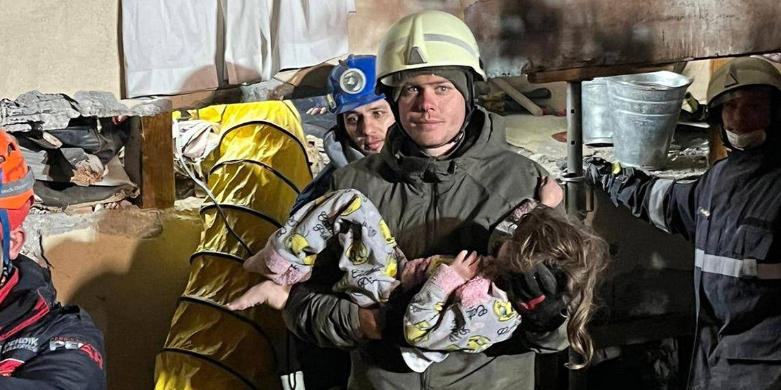 Sergeant Daniel Degenhart holds the girl in his arms who was rescued by AFDRU (Austrian Forces Disaster Relief Unit) soldiers on Friday night.