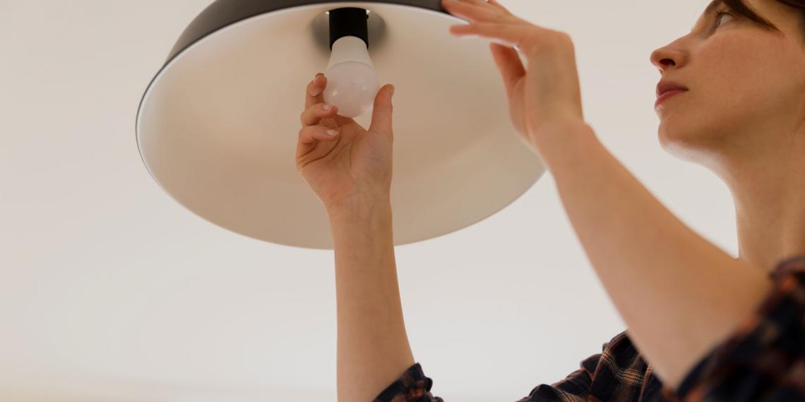 Lady changing a light bulb