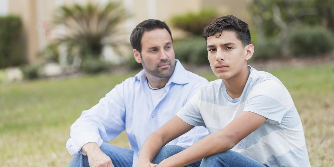 a man talking with his teenage son